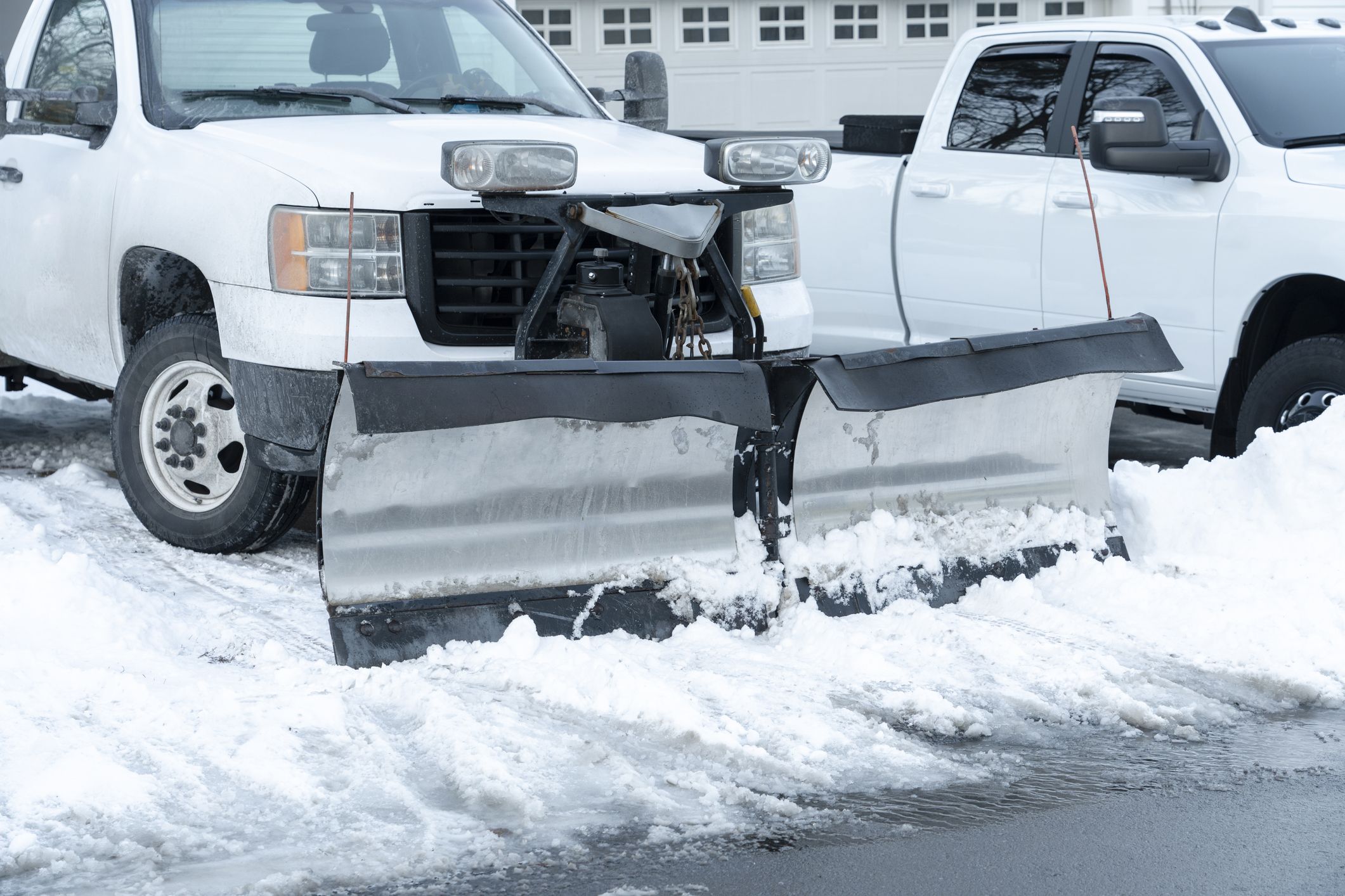 truck with snowplow installed on the driveway ready to clear snow